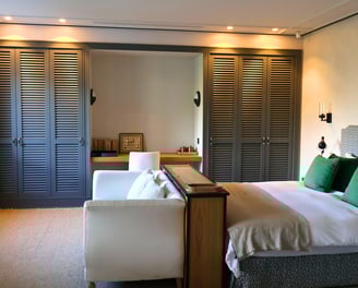 Elegant bedroom with Hamptons-style wardrobes, botanical mural, and soft neutral linens