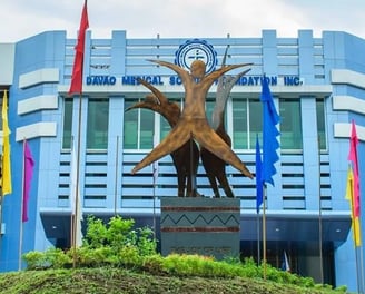 a statue of a woman holding a child in front of a building