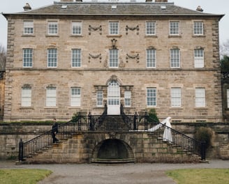 a large stone building with a staircase leading to a stone building