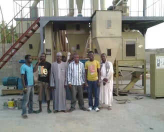 a group of men standing in front of a machine