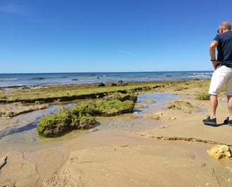 Man die geniet van de prachtige kustlijn van Praia do Barranco