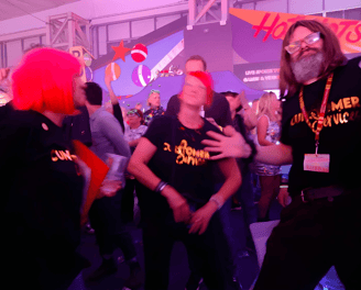 a group of people dancing whilst wearing the same printed black t-shirts