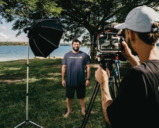 Man standing outside in front of professional video camera setup with camera operator