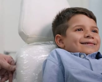a young boy sitting in a chair in a hospital