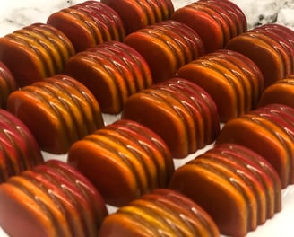 Handcrafted chocolates with cocoa butter decoration in vibrant colors luxury shine chocolates from ChocosCookiesCakes