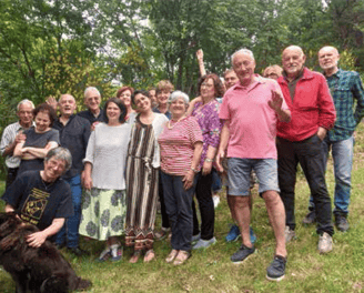 a group of people standing in a field with a dog