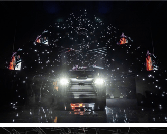 A car launch event featuring dynamic lighting, digital visuals, and an intricate stage design with a