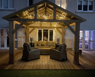 Modern Gazebo with feature lighting, patio heaters and large sofa.