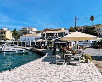 a group of people sitting at tables near a dock