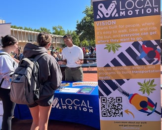 Photo of people visiting a Local Motion booth speaking with a staff member