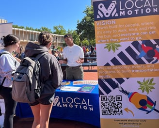 Local Motion table with a staff member talking to the public