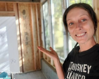 a woman smiling as she shows the construction progress of her dream studio space
