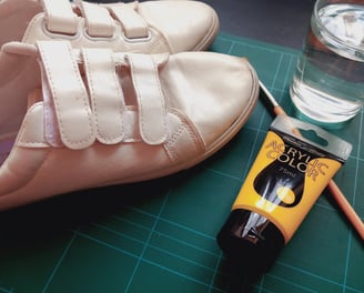 a pair of shoes and a brush on a table