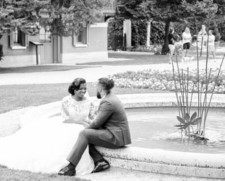un couple assis sur une fontaine se regardant avec amour