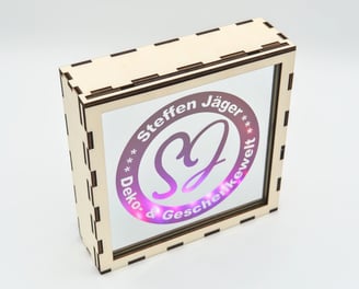 Holzkasten mit einem Spiegel, auf dem Spiegel ist das Logo dieser Webseite vorhanden, Lila beleuchte