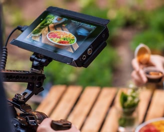 a person holding a camera and taking a picture of a person holding a drink