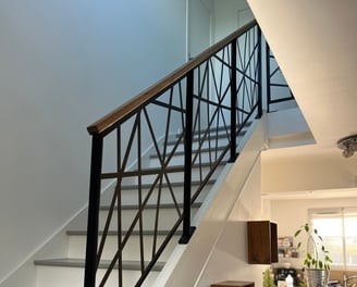a staircase with a metal railing and a glass railing