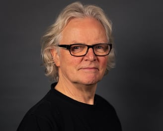 Gerhard Rohlfs, ein Mann mit Brille vor einem Grauen Hintergrund, Portrait