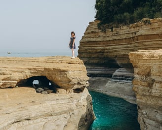 a woman standing on a cliff overlooking the ocean