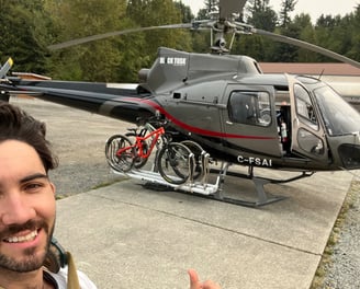 a man standing next to a helicopter with bikes