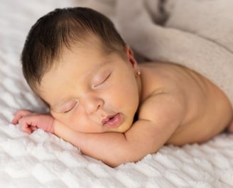 Sessió de fotos newborn a Girona amb una bebè recent nascuda dormint en estudi fotogràfic