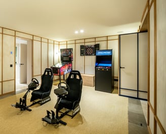 Game room at Villa La Gratitud with PlayStation simulators, pinball, arcade, and darts.