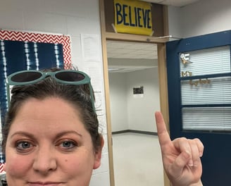 Woman with sunglasses standing in a classroom