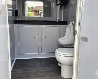 the inside of a men's bathroom inside the 2 stall luxury restroom trailer