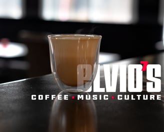 product image of a latte in a clear glass with Elvio's Coffee text in the image