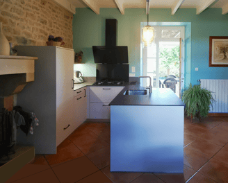 Cuisine beige et plan de travail pierre. Cuve inox, hotte murale, plaque cuisson gaz. Ilot central.