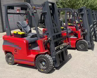 a row of forklift trucks parked in front of a building