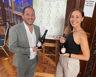 Alex Duffy and Nicola Lashley holding bottles of Prosecco.