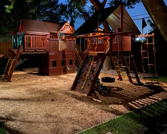 landscape lights installed on a swing set for a kids playground