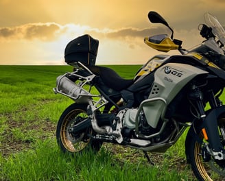 Remy Luxury Helmet Bag resting on a motorcycle seat with the sun setting in the background,