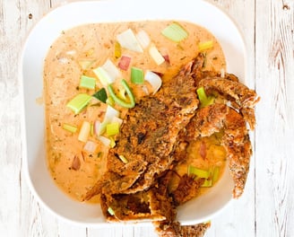 a bowl of soup with a fried crab