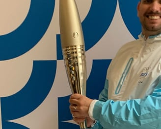 Tim Dougill holding the Paris24 Olympic torch.