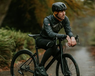 man presenting his helmet and his cycling jersey