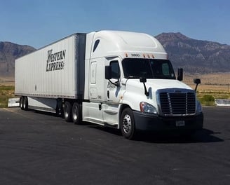 a semi truck with a dry van parked at a truckstop