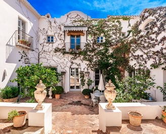 Rustic Spanish villa for rent featuring a charming ivy-covered patio