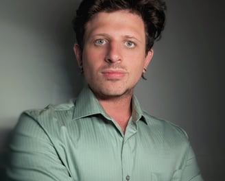 a white man with earrings wearing a green shirt