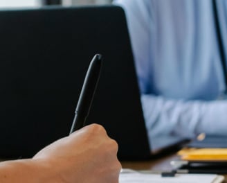 a man sitting at a table with a notebook and pen