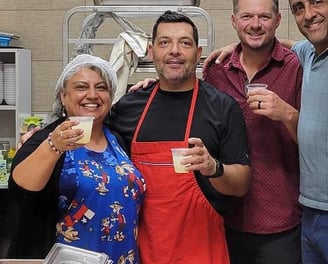 a group of people standing in a kitchen