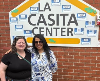 Two women standing in front of the La Casita Center building signage