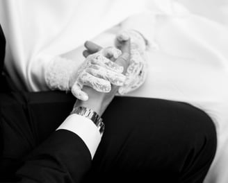 a man in a suit and tie tie holding a woman's hand