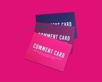 A stack of three event comment cards in pink, maroon, and navy blue.