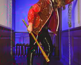 FTSH Studios model (s) Oscar Thickk UK Fetish Model wearing red vinyl jacket, latex shirt and leather riding boots
