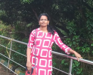 a woman in a pink dress standing on a bridge
