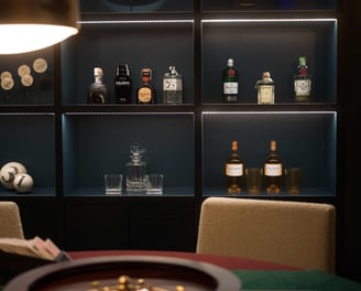 Bar shelf at Villa La Gratitud, with premium spirits, crystal glasses and roulette wheel.