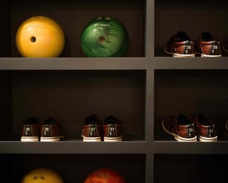 Bowling balls and shoes organized on shelves in the private bowling alley at Villa La Gratitud.