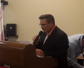 a man in a suit and tie is standing at a podium with a microphone